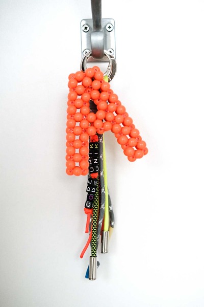 Bag tassel with orange “A” on it